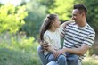 © New Africa - Smiling father and his daughter looking at each other outdoors on sunny day. Space for text