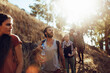 © Marko Geber - Group of friends hiking on sunny forest trail