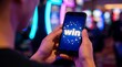 © Stocker - Man plays mobile game with word win displayed on screen, casino background with neon lights, close up of hands holding smartphone, concept of online gambling success and digital entertainment winning.