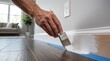 © Creative Concepts  - Hand painting white baseboard trim with a brush in a modern home