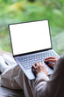 © Farknot Architect - Vertical mockup image of a woman working on laptop computer with blank desktop white screen on the bed at home