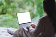 © Farknot Architect - Mockup image of a woman working and typing on laptop computer with blank desktop white screen on the bed at home