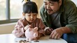 © TE - Engaging moment young asian parent and child saving coins together with a piggy bank in a cozy setting