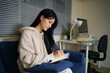 © Stella 16 - Young Asian Woman Using Digital Tablet with Stylus Pen at Home Study Room