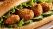 © miss irine - Sesame crusted chicken strips fill a long bun with lettuce and cucumber slices. Savory chicken chunks are stacked generously inside a fresh white bread roll. Delicious meal ready for eating.