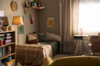 © DragonImages - Wide angle view of child bedroom featuring study desk, backpack, books, bed, and school supplies, presenting home learning routine and back to school marketing use