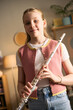 © DragonImages - Portrait of Caucasian girl holding flute and studying music, practicing instrument skills for creative education and youth development. Ideal for music school promotion or lesson ads, vertical