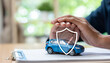© Father_Studio - Car insurance protection concept featuring vehicle model under protective hands and shield icon, representing auto coverage, risk management, financial security, policy protection, and safe ownership.