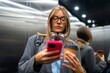 © Artcore Studio/Stocksy - Woman using phone in elevator with coffee cup