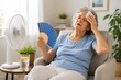© martenaba - Senior woman suffering from heat wave, feeling unwell