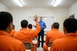 © Moopingz - In a prison classroom, an inmate in an orange jumpsuit raises his hand during a group lecture.