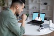 © Prostock-studio - Focused Man Thinking And Consulting With Black Doctor On Screen While Sitting At Home Office Desk. Engaging In Telemedicine Session For Health Advice And Guidance In Comfortable Environment.