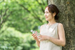 © buritora - A relaxed woman drinking bottled water, mineral water, and hot water.