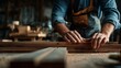 © TensorSpark - Carpenter hand using woodworking tool to plane and shape a wooden board on a workshop bench, close up of hand, wood grain and bench.
