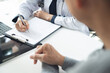 © tippapatt - Doctor and patient at hospital office. Doctor working on diagnostic examination on men's health disease and writing on prescription record information document at medical clinic, close up