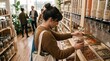 © DramaReelVault - Woman shopping for bulk nuts and grains in a zero waste eco-friendly grocery store, sustainable lifestyle concept, customer filling glass jar at refill station