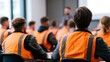 © Kate - Workers in safety vests attending corporate training session in a modern office