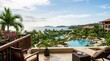 © Keo - A person relaxes on a balcony overlooking a luxurious resort. The balcony features wooden chairs and a small table with a cocktail.