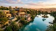 © Jarot - Luxury resort oasis in desert with tranquil lake and traditional architecture at sunset