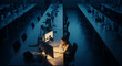 © Kalpona - Stressed female employee working late at night in empty dark open space office