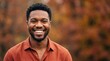 © Ccraftz - Smiling young African American man standing outdoors in autumn