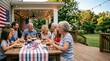 © Vera D - Title: Multi-Generation American Family Celebrating Independence Day with Barbecue Dinner on Backyard Wooden Deck Porch Decorated with USA Flags and String Lights.
