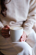 © Farknot Architect - Vertical closeup image of a woman holding and drinking hot coffee in cafe