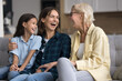 © fizkes - Older woman her grown-up daughter and preteen granddaughter having fun, enjoy conversation, laughing, talking, joking, feel overjoyed spend priceless, carefree time together on weekend leisure at home