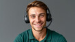 © Nick Freund - Junger Mann mit Headset im grünen Polo-Shirt lächelt vor grauem HintergrundKeywords: