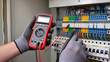 © Jakub - Electrician testing electrical panel with multimeter