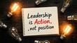 © muhammadHafeez - Open notebook with handwritten inspirational text leadership is action not position on rustic wooden table