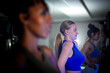 © ultramansk - A focused group of diverse women practicing yoga and stretching during a fitness class in a modern gym with atmospheric blue low light.
