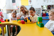 © AresStudio Belen y Carlos/Stocksy - Teacher assisting young children playing with building blocks