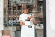 © Aleksandra Jankovic/Stocksy - Smiling Shop Owner Examining Skincare Serum Bottle in Boutique