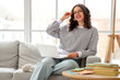 © Pixel-Shot - Female Indian student studying with laptop on sofa at home