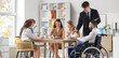© Pixel-Shot - Young man in wheelchair using laptop with human resources commission during job interview at office