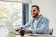 © Daniel - Young professional man with a beard smiling, working and typing on a laptop computer at a desk, enjoying remote work and digital nomad lifestyle from a bright home office