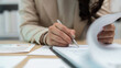 © Korakot - Close-up of hand writing on documents in office