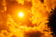© Chandet - Dramatic blazing sun shining through fiery orange clouds during an extreme heatwave, global boiling and climate crisis concept, hot summer weather background.