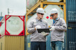 © Wanwajee - Logistics supervisors review shipment documentation and cargo verification records at container terminal, supporting freight transportation planning and supply chain management operations.