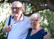 © luciano - Happy mature couple smiling at the camera, embracing outdoors, showcasing their strong bond, love, and contentment during their golden years