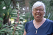 © luciano - Senior adult woman smiling cheerfully outdoors in a green garden, showing a positive attitude and enjoying a healthy lifestyle while connecting with nature