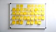 © Gomastudio - 会議室のホワイトボードに黄色付箋が大量に貼られた企画整理風景