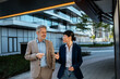 © Davor - Business colleagues talking while walking outside office complex