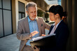 © Davor - Two business colleagues discussing project outside office building
