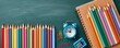© Georgii - Colorful school supplies flat lay with colored pencils, notebook and alarm clock on chalkboard