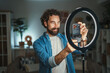 © Miljan Živković - Man creating video content with smart phone and ring light