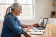 © Trinette Reed - Senior woman taking blood pressure on a Telehealth video call with her doctor from home