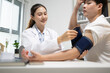 © Somdetmeaow - Doctor records patient's blood pressure reading. Patient rests arm with cuff securely fitted. Clinic setting suggests routine health monitoring. Professional demeanor shows care and precision