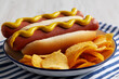© Liudmyla - Homemade Hot Dog with Potato Chips on a Plate, low angle view. Close-up.